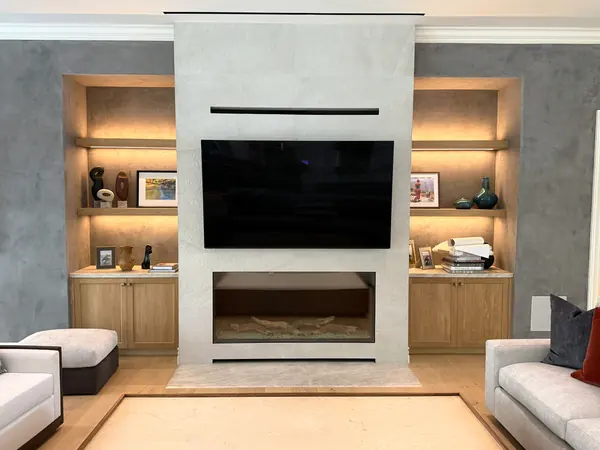Fireplace media wall flanked by lit niches with oak shelves and base cabinets, Thousand Oaks