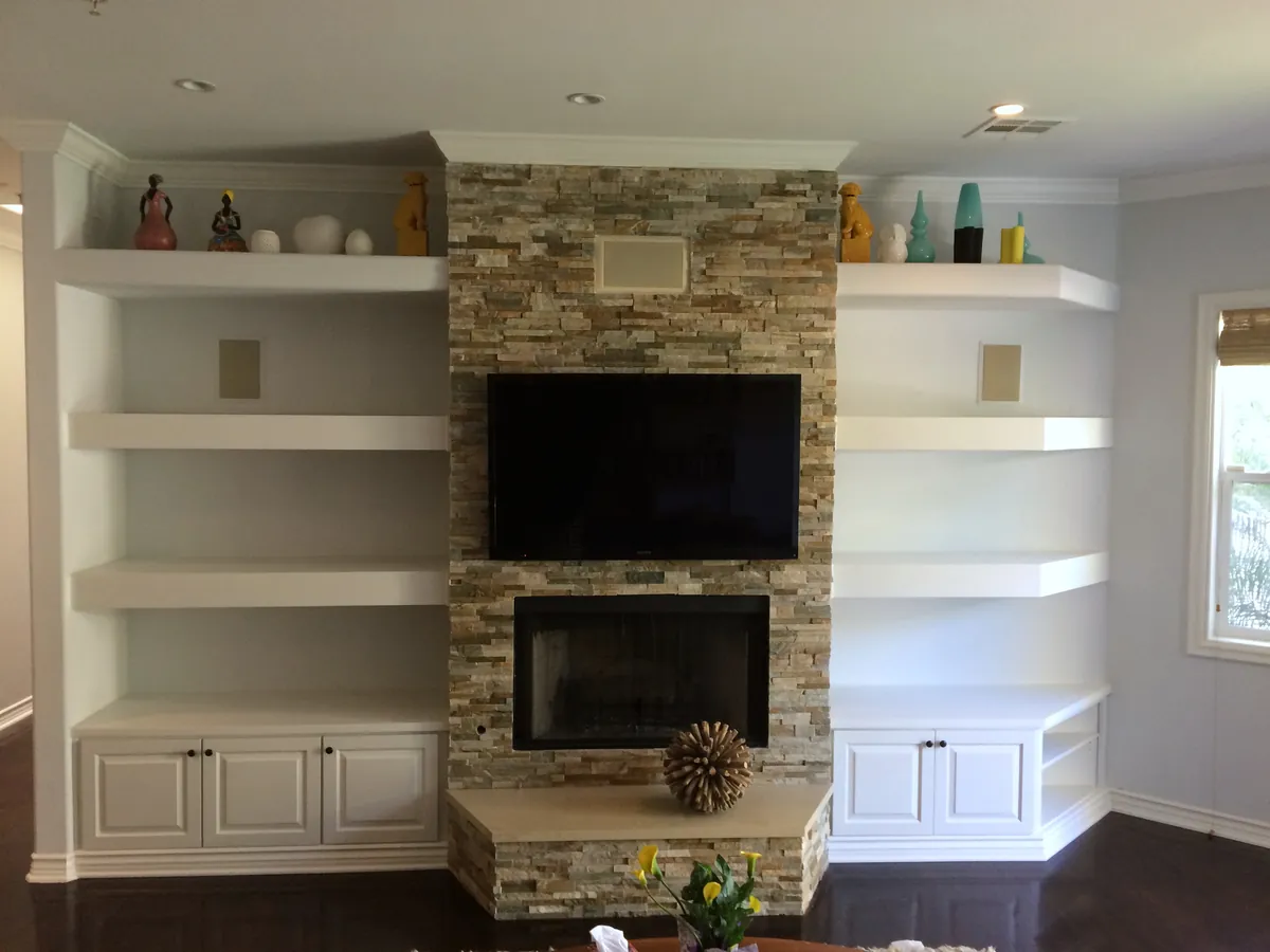 Fireplace wall with white floating shelves and base cabinets on both sides, Woodland Hills
