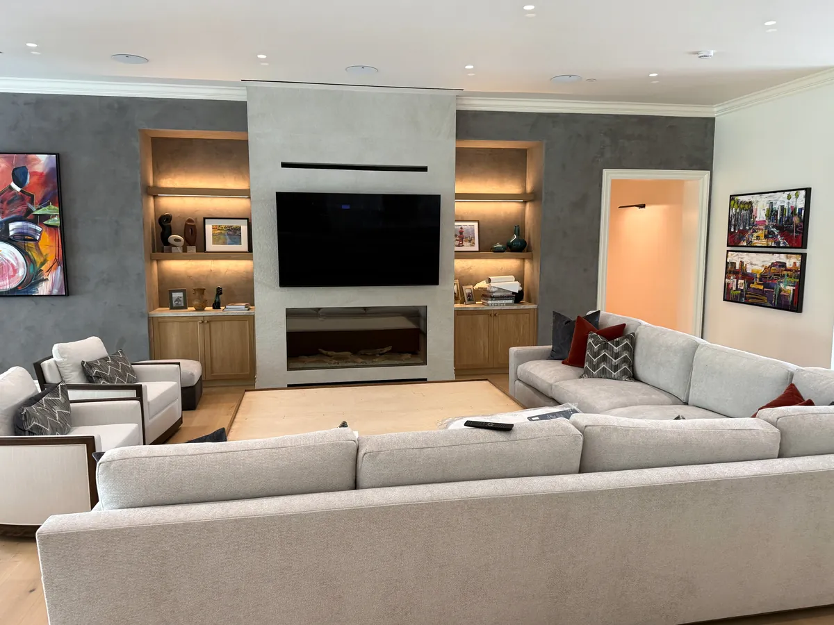 Living room media wall with lit oak niches and base cabinets on both sides of the fireplace, Thousand Oaks