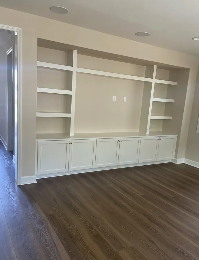 White media built-in with open shelving over shaker base cabinets