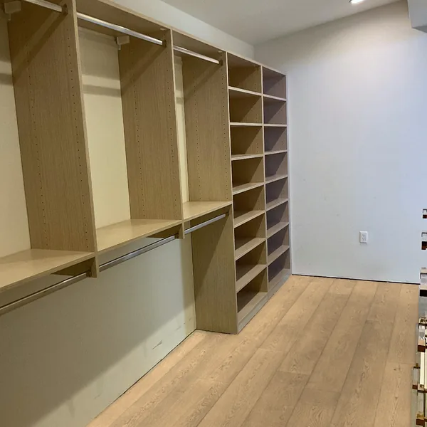 Walk-in closet system with double hanging rods and a tall open shelving tower