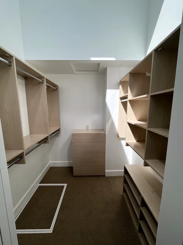 Walk-in closet under a skylight with double hanging on both sides, shoe shelves and a drawer unit, Solvang