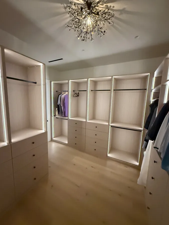 Walk-in closet with LED-lit hanging sections above drawer stacks, Thousand Oaks