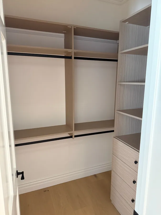 Closet with double hanging rods, a shelf tower and drawers with black knobs, Thousand Oaks