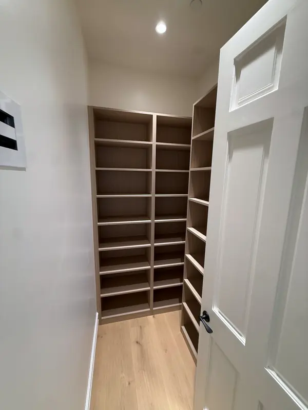 Narrow closet lined with floor-to-ceiling adjustable shelves, Thousand Oaks