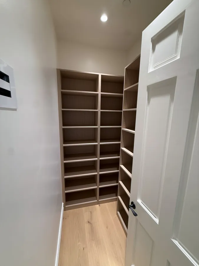 Narrow closet lined with floor-to-ceiling adjustable shelves, Thousand Oaks