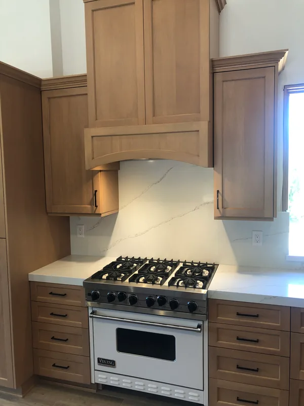 Light oak shaker range hood and upper cabinets over a pro-style range, with drawer stacks on both sides, Santa Rosa Valley