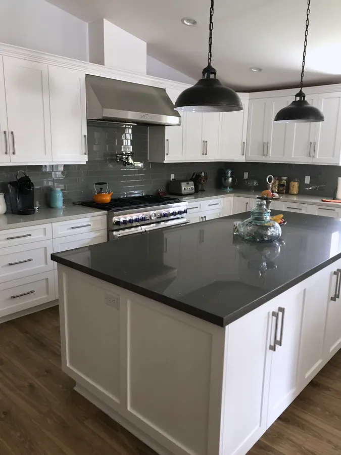 White shaker kitchen with a gray island and a dark countertop