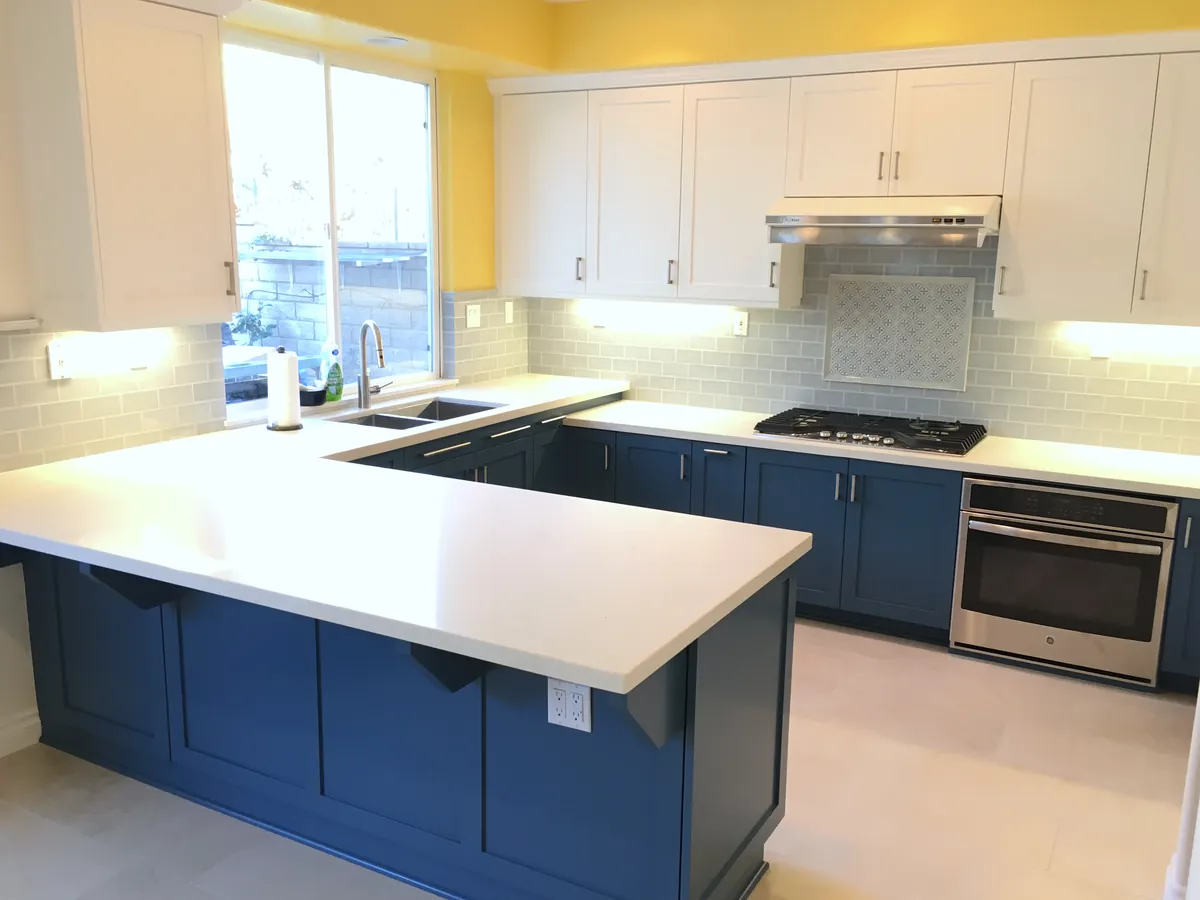 Kitchen with navy base cabinets, white uppers and a peninsula, Thousand Oaks