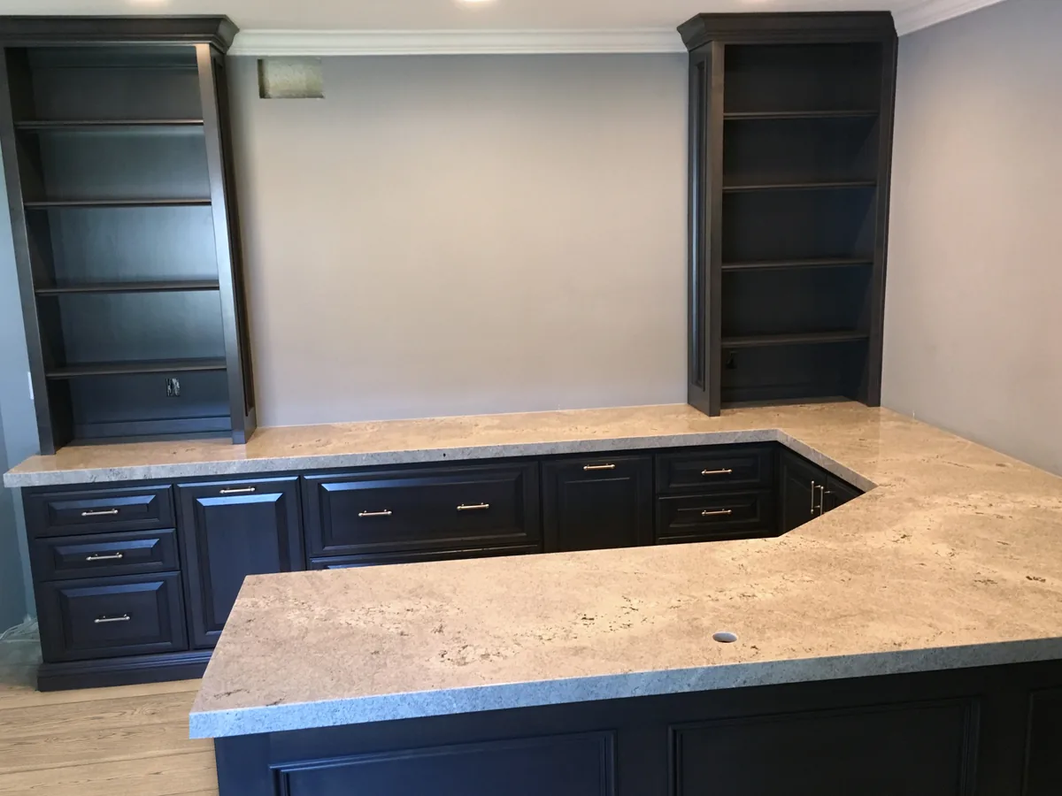 Navy home office desk run and peninsula with a stone top and bookcase towers