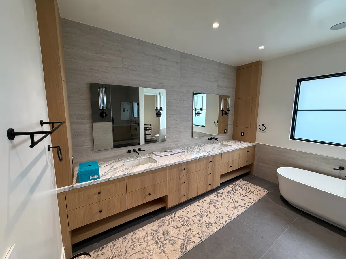 Long floating oak double vanity with an open shelf below and tall side cabinets, Thousand Oaks