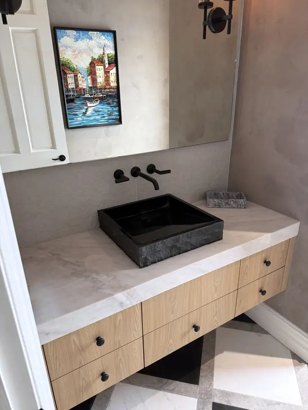 Floating oak vanity with a black vessel sink and a white stone top, Thousand Oaks