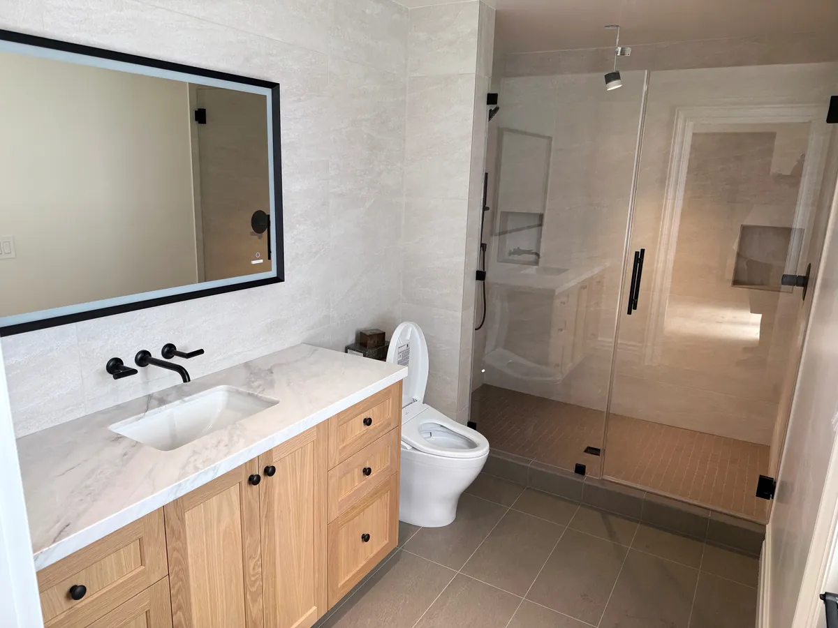 Oak shaker vanity with a wall-mounted faucet beside a glass shower, Thousand Oaks