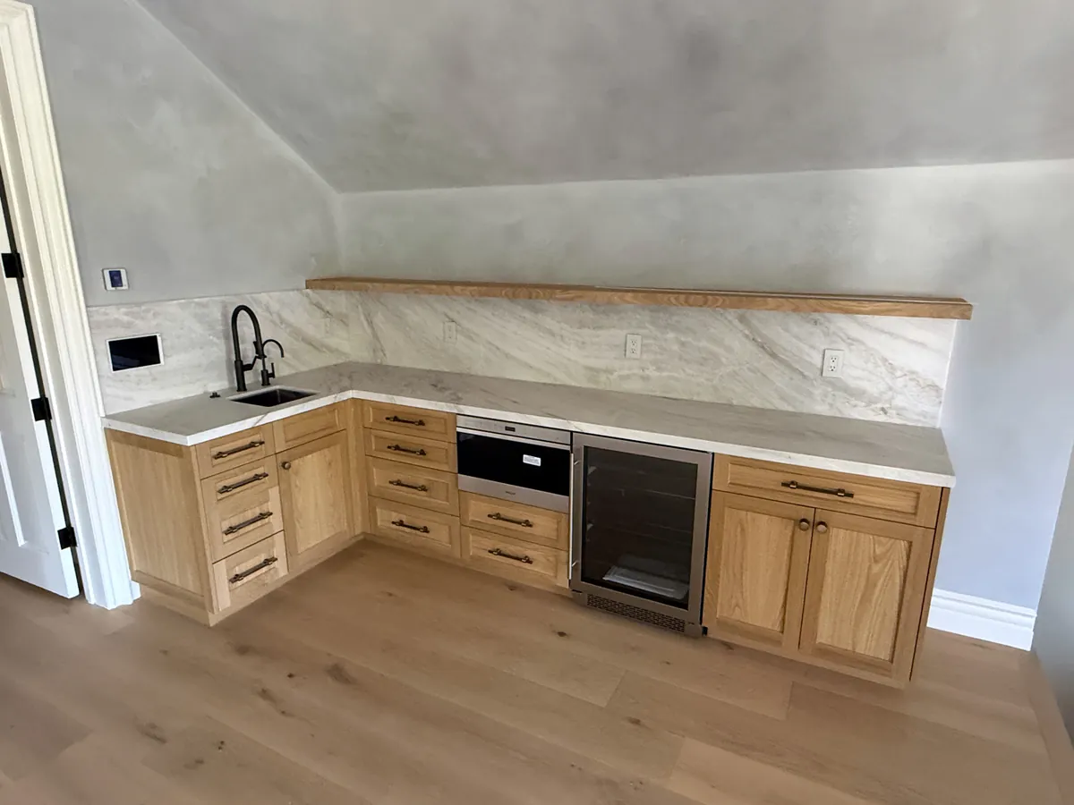 Oak shaker wet bar with a wine fridge, a floating shelf and a stone backsplash, Thousand Oaks