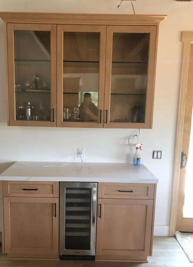 Wood bar hutch with glass-front uppers and a wine fridge